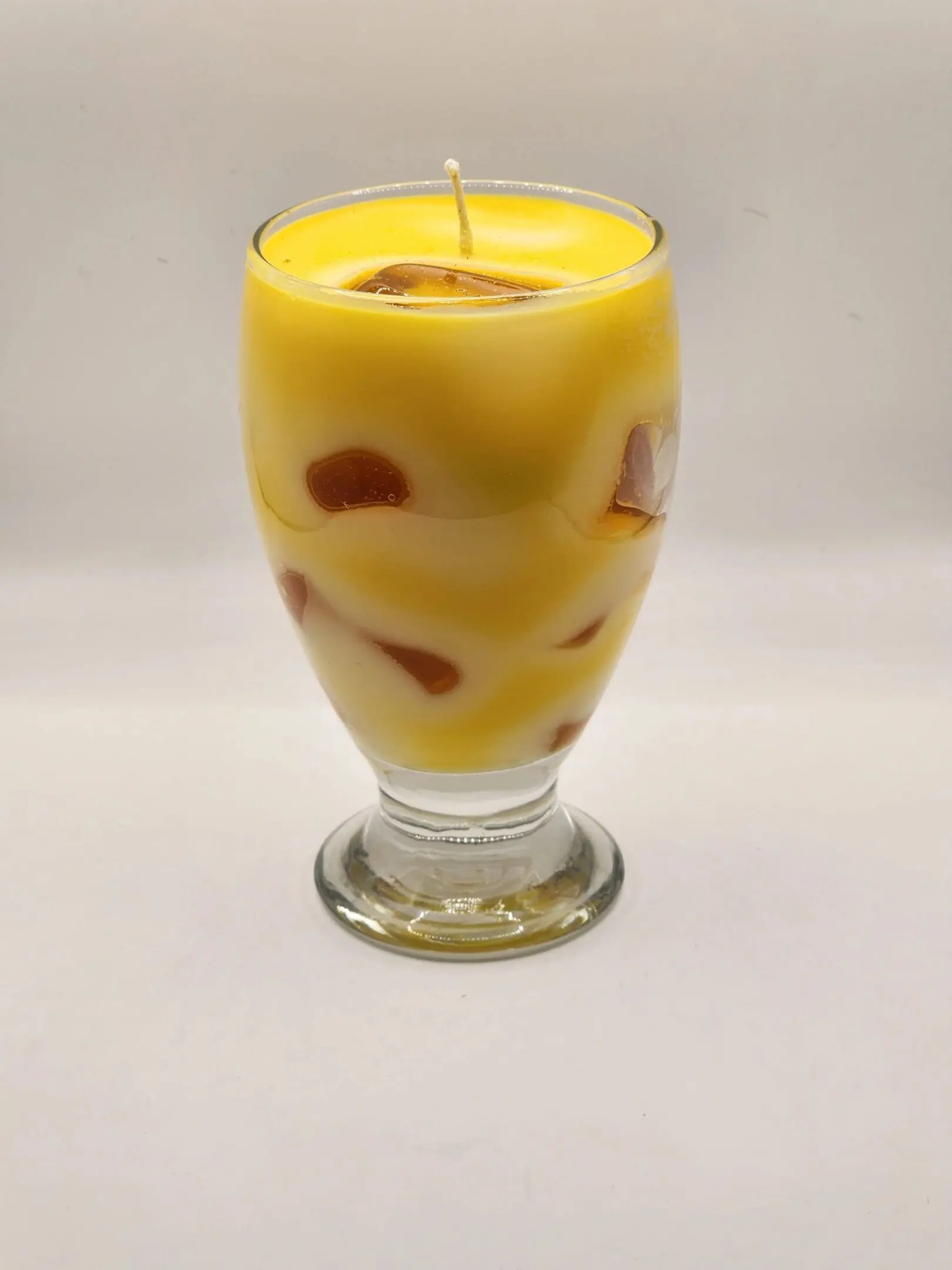 A candle in the shape of a glass.