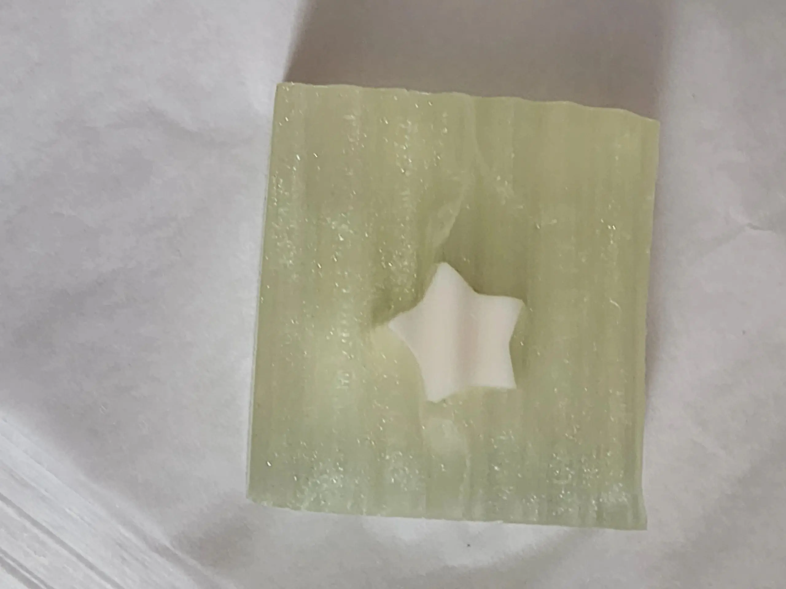 A star shaped soap sitting on top of a white sheet.