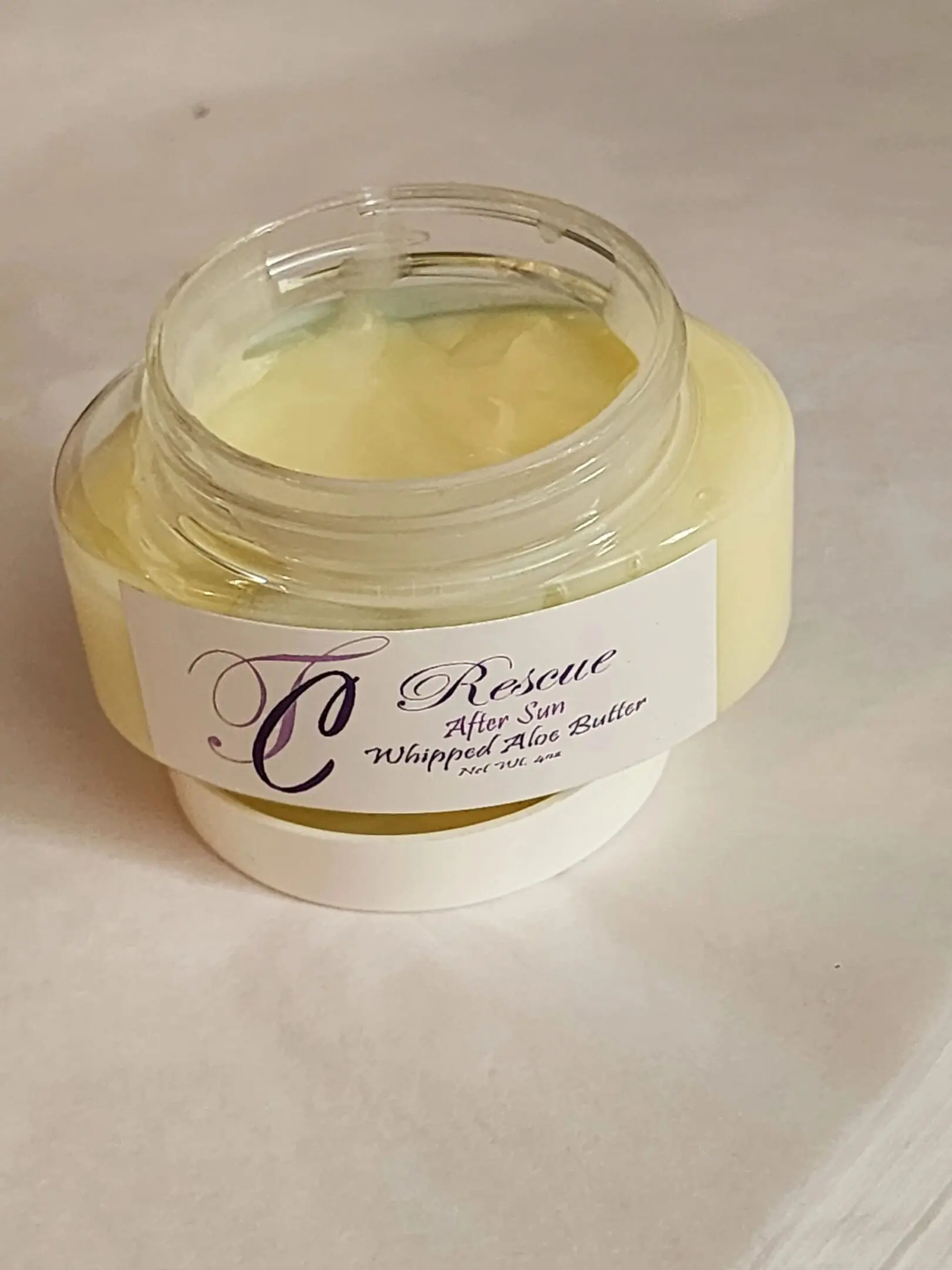 A jar of whipped body butter sitting on top of a table.
