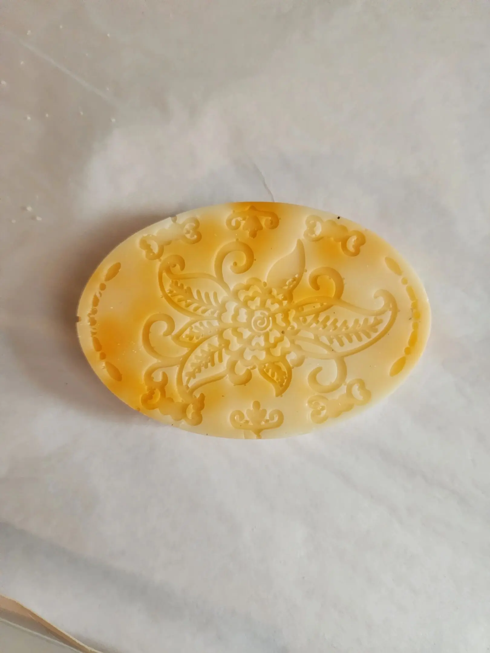 A soap with a pattern on it is sitting on paper.