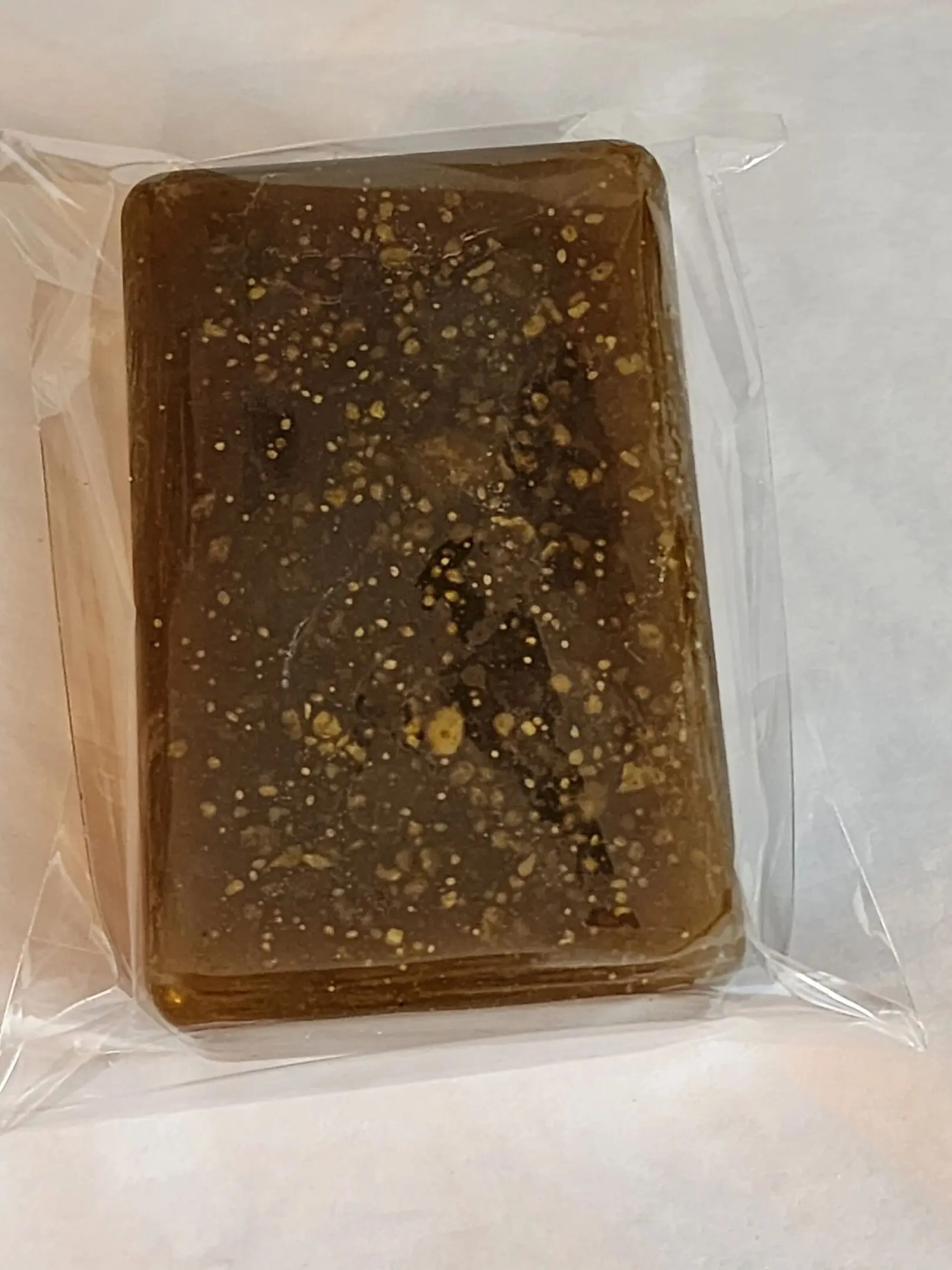 2023-08-05-11.54.29-ae0f1c1 A piece of chocolate cake in plastic wrap.