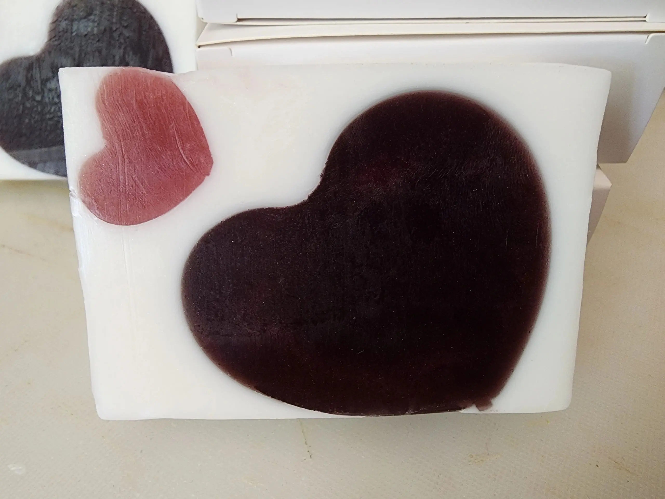 A heart shaped cake with chocolate frosting on top.