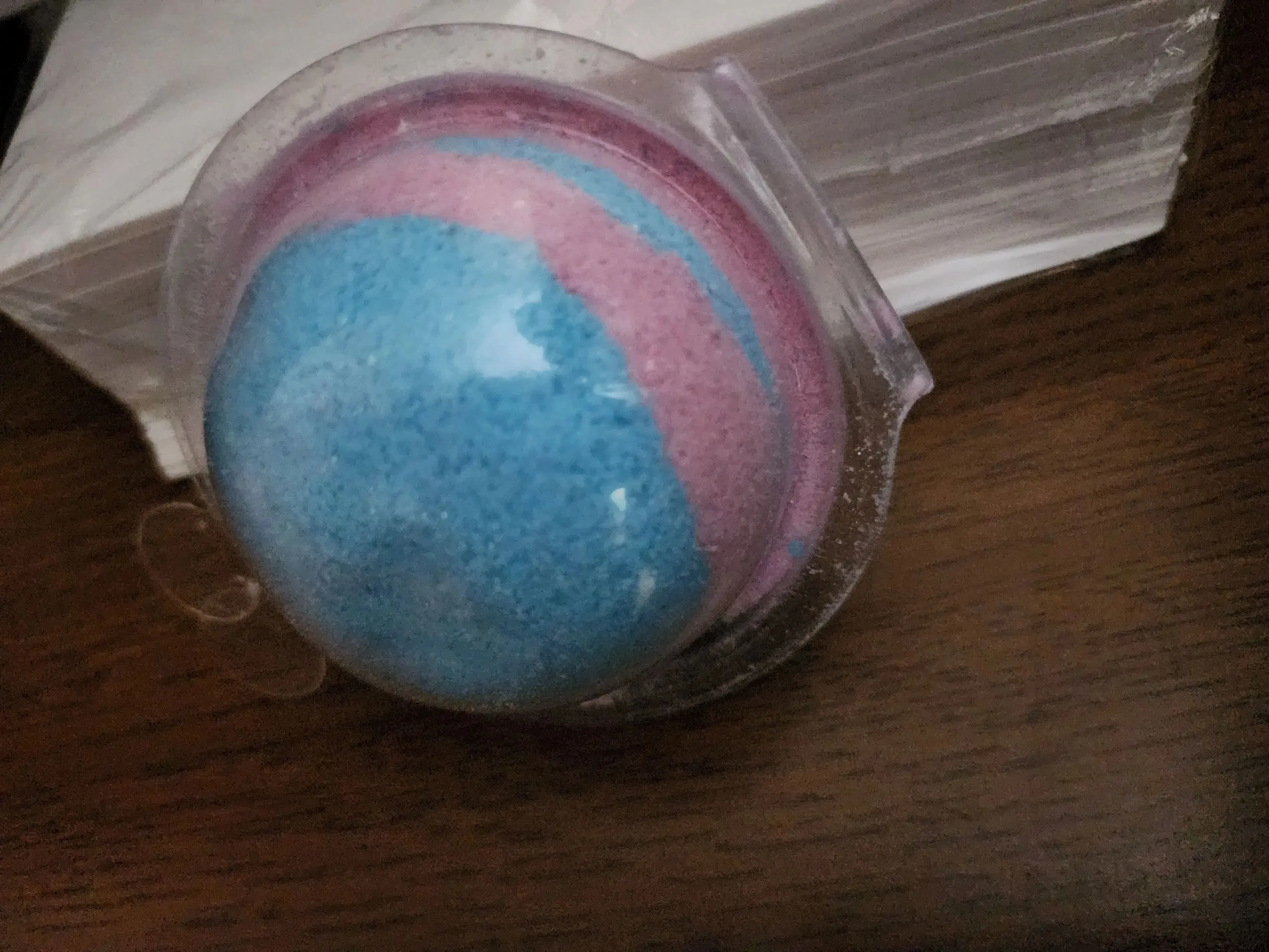 A bath bomb sitting in a plastic container.