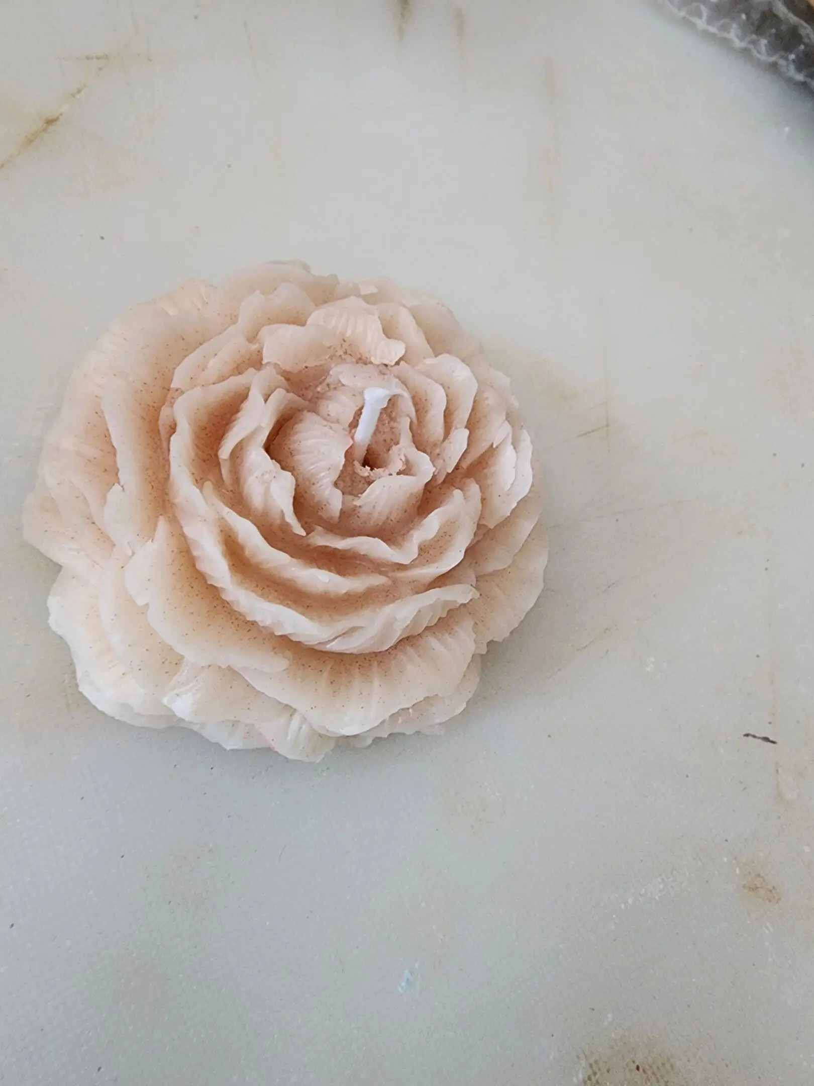 A candle that is shaped like a flower.