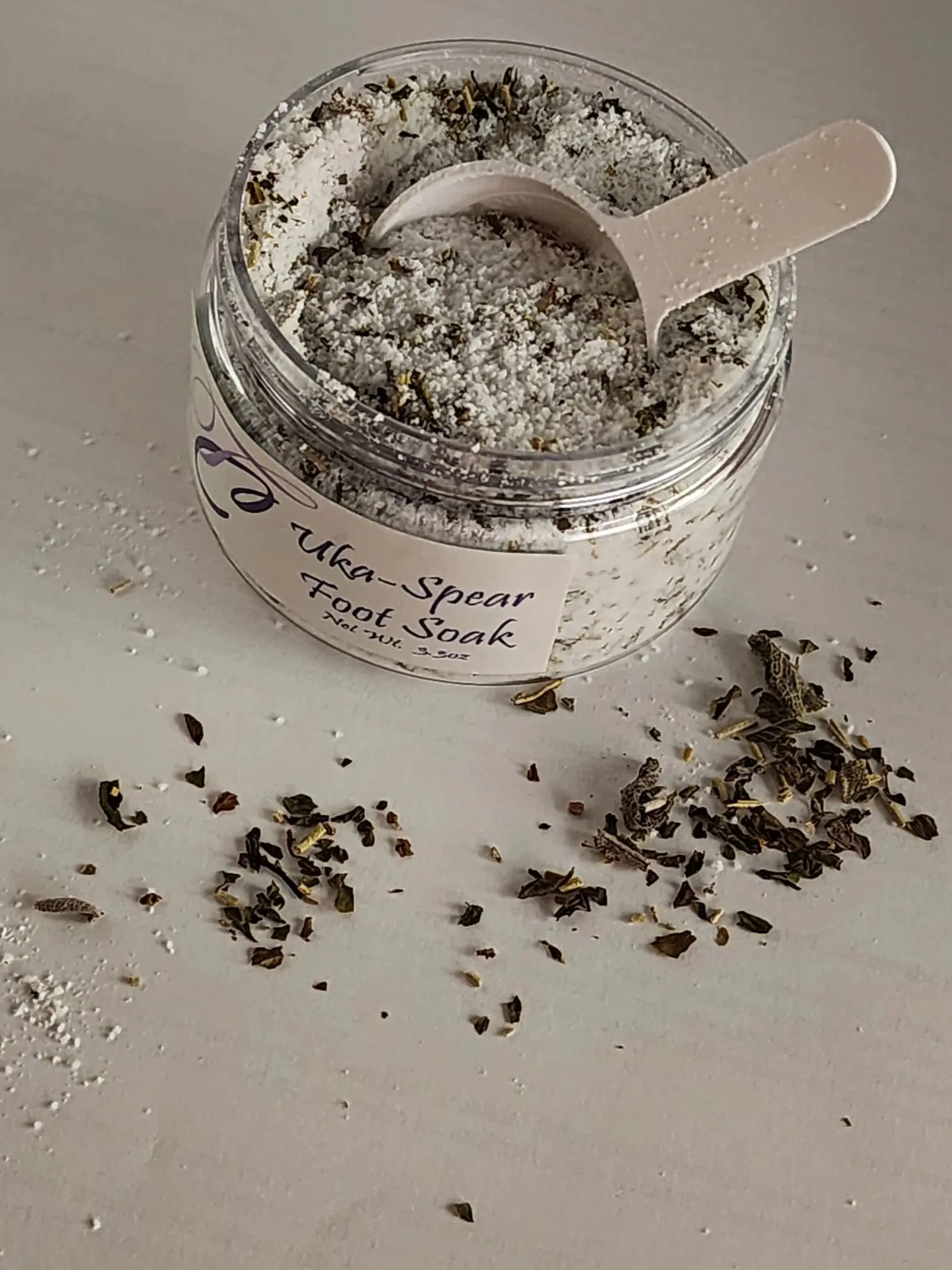 A jar of dead sea salt with a wooden spoon.