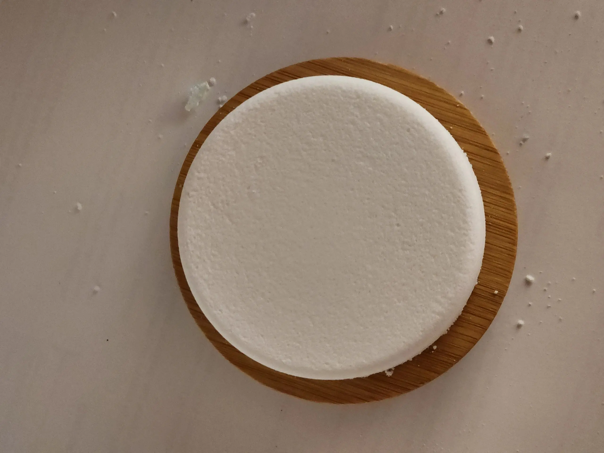 A wooden plate with some white cake on it