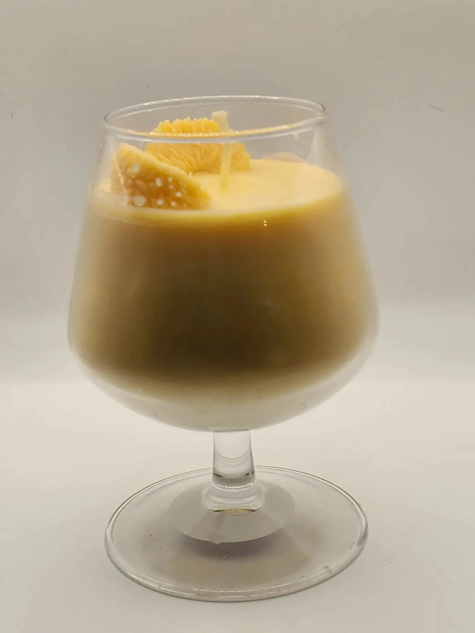 A glass of orange juice with an orange slice in it.
