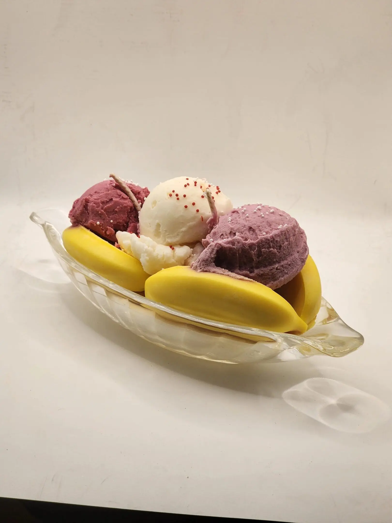 A bowl of ice cream and fruit on top of a table.