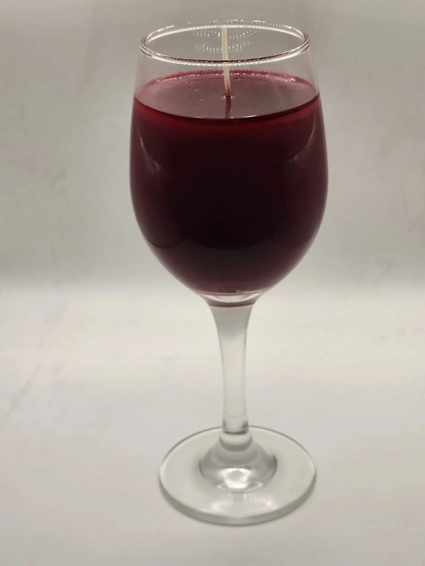 A candle in a wine glass on the table