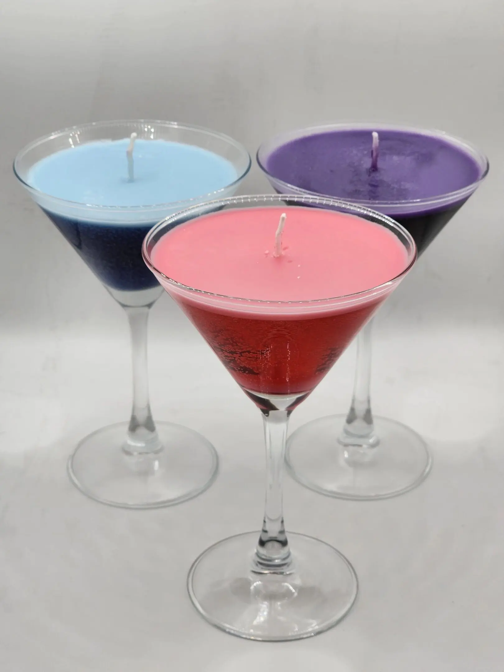 Three glasses of candles are sitting on a table.