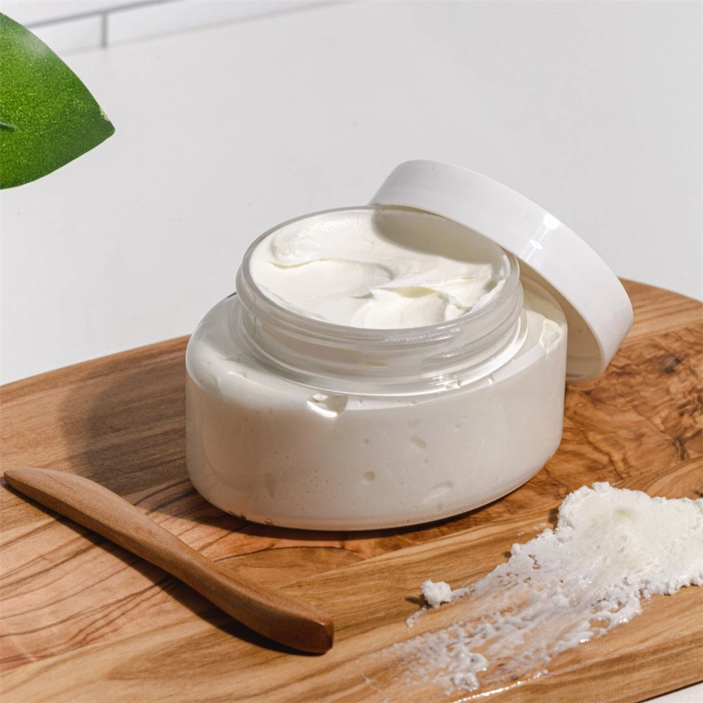 A wooden table with a jar of face cream and some powder.