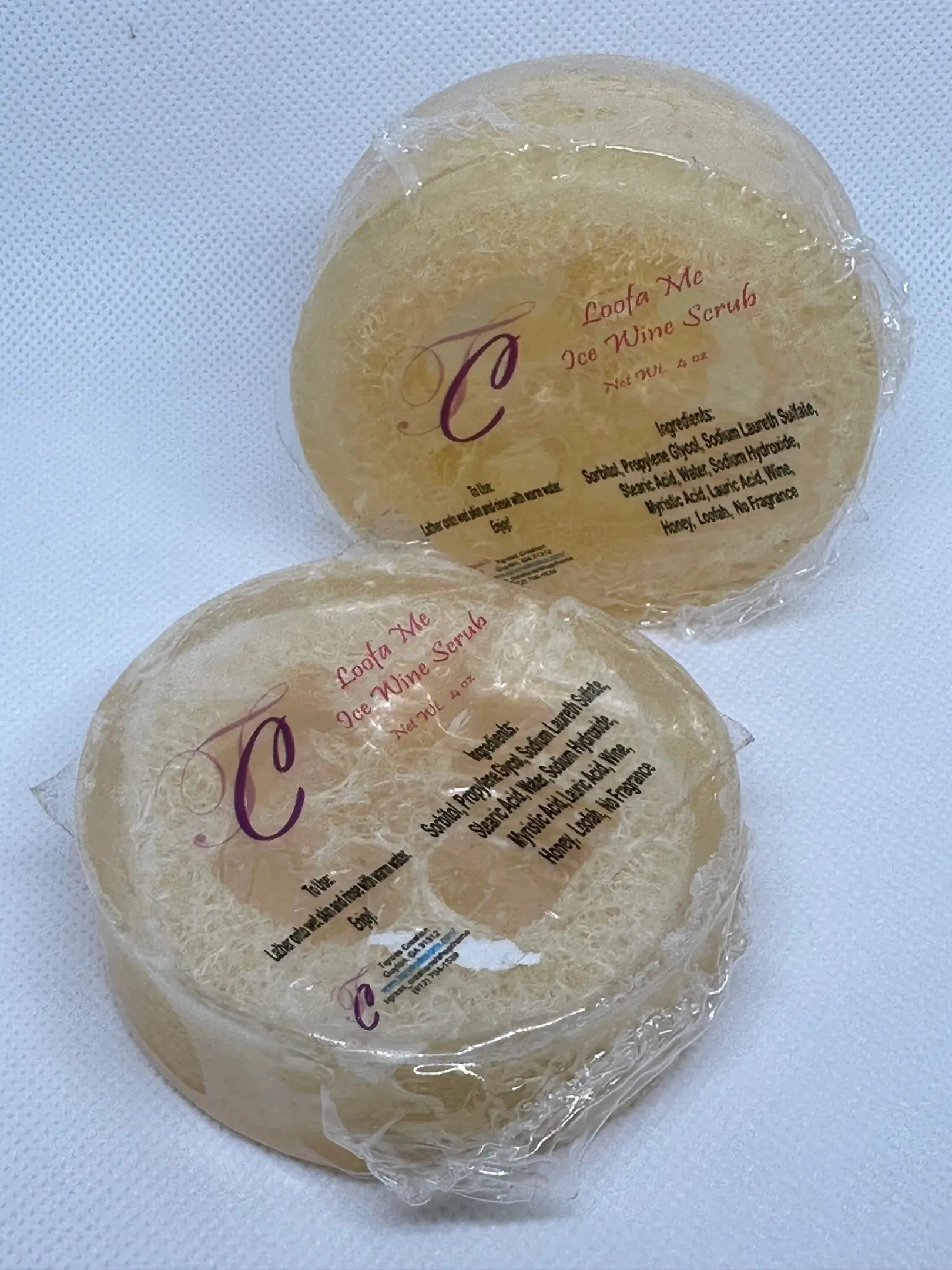 A close up of two round cakes wrapped in plastic