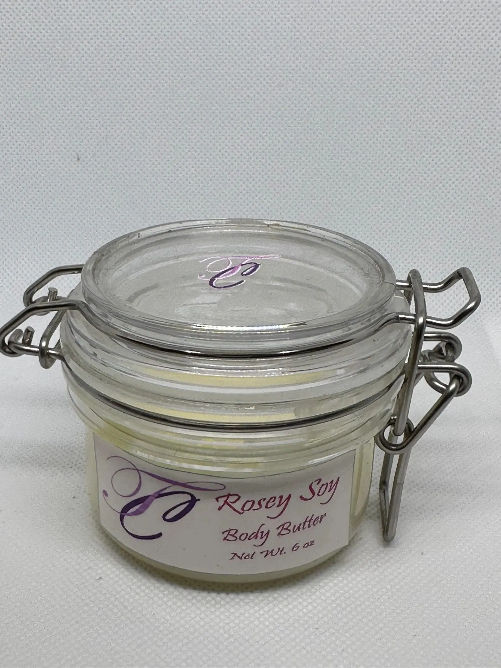 IMG_0368 A jar of body butter sitting on top of a table.