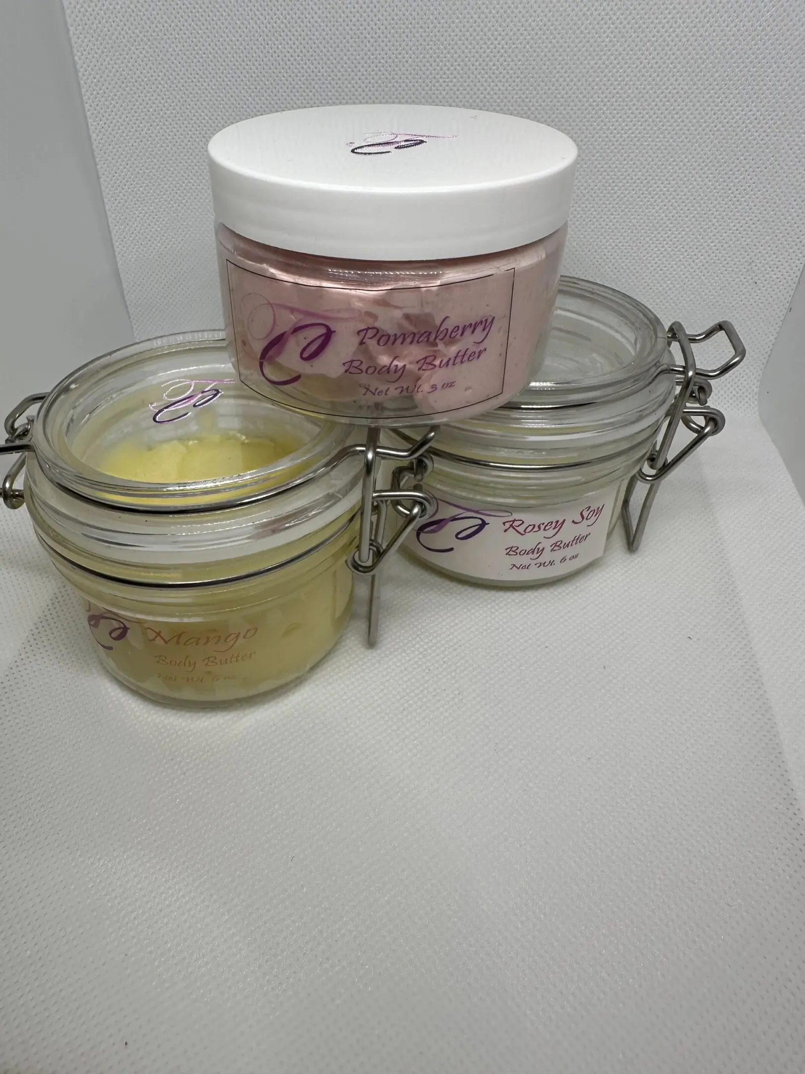 Three different types of body butters are sitting on a table.