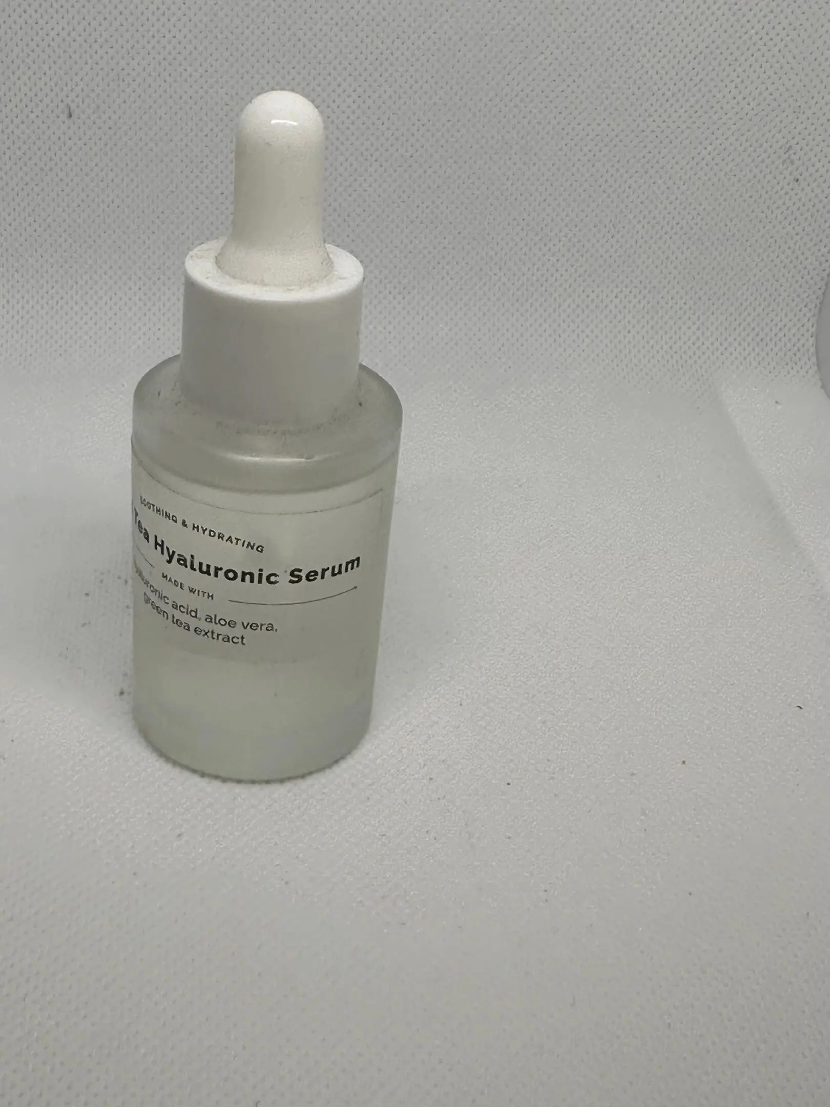 IMG_0393 A bottle of serum sitting on top of a table.