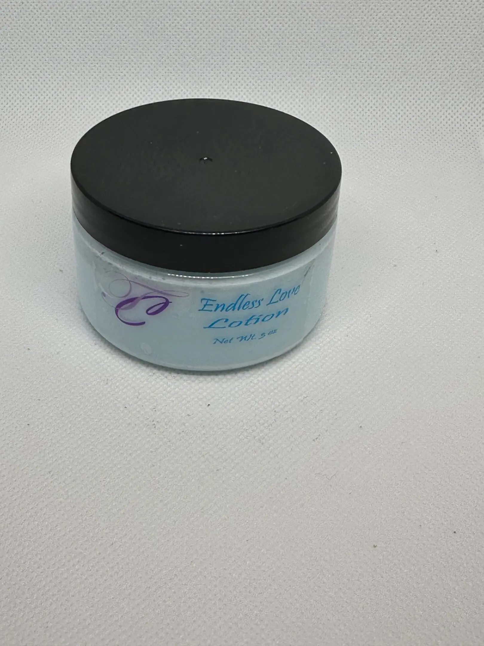 A jar of body butter sitting on top of a table.