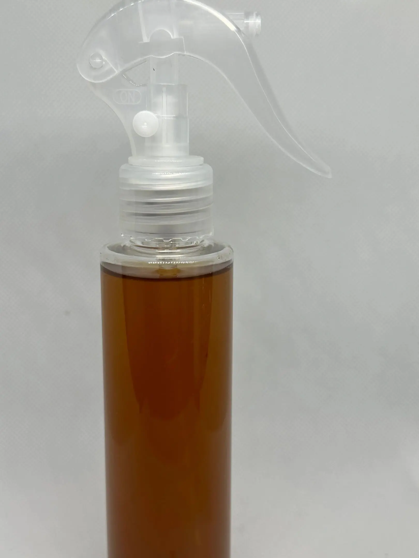A spray bottle with a white cap on it.