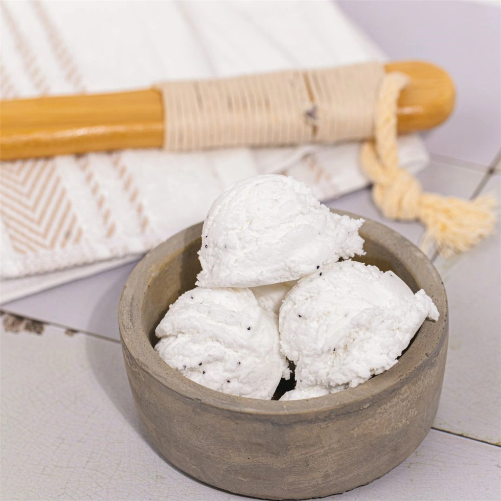 A bowl of ice cream next to a wooden spoon.