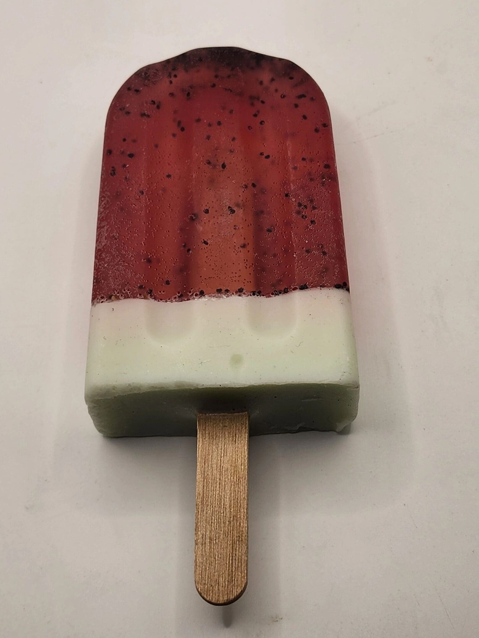 A popsicle with red and white icing on top.