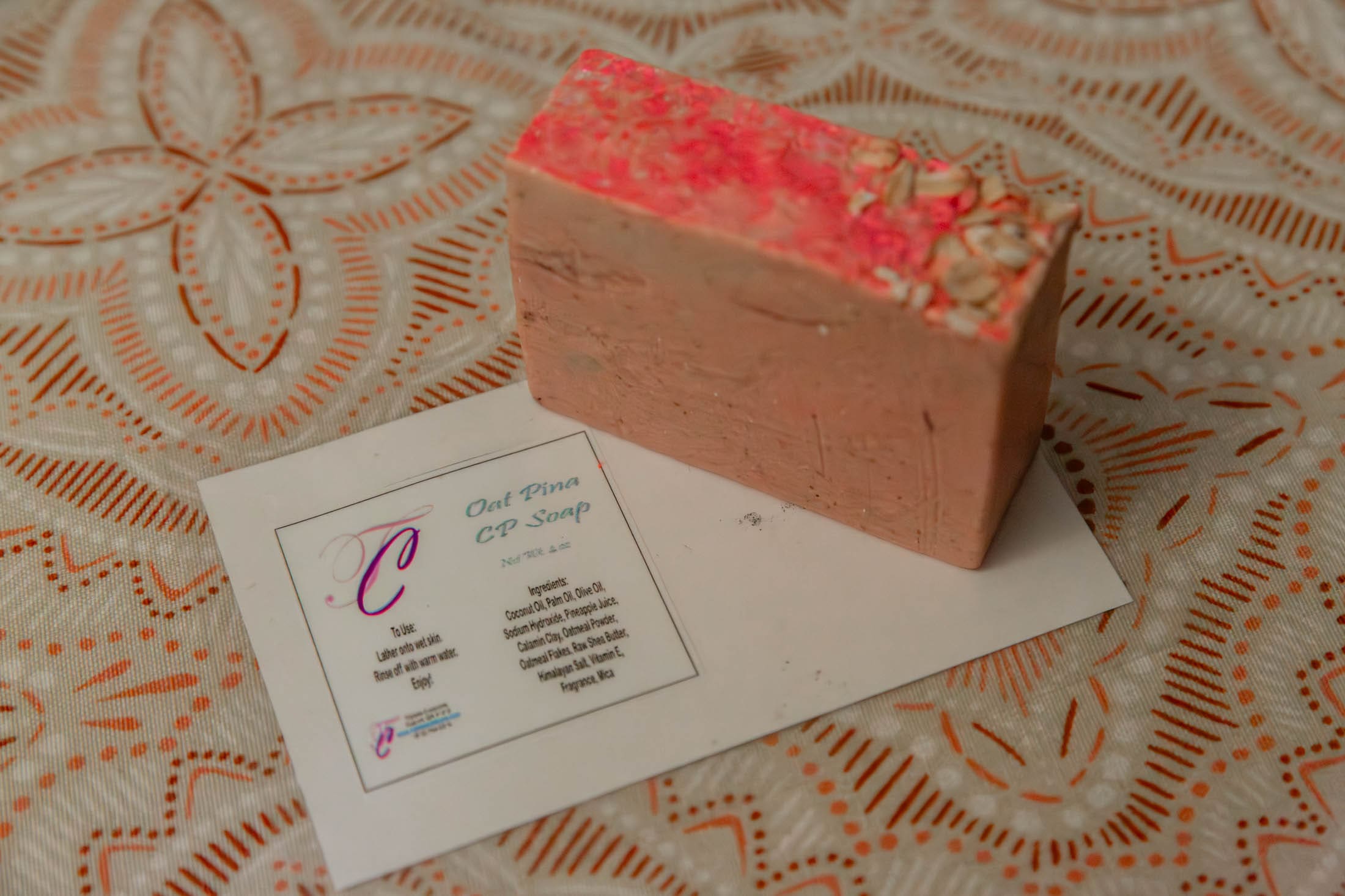 Soap and card on decorative tablecloth.