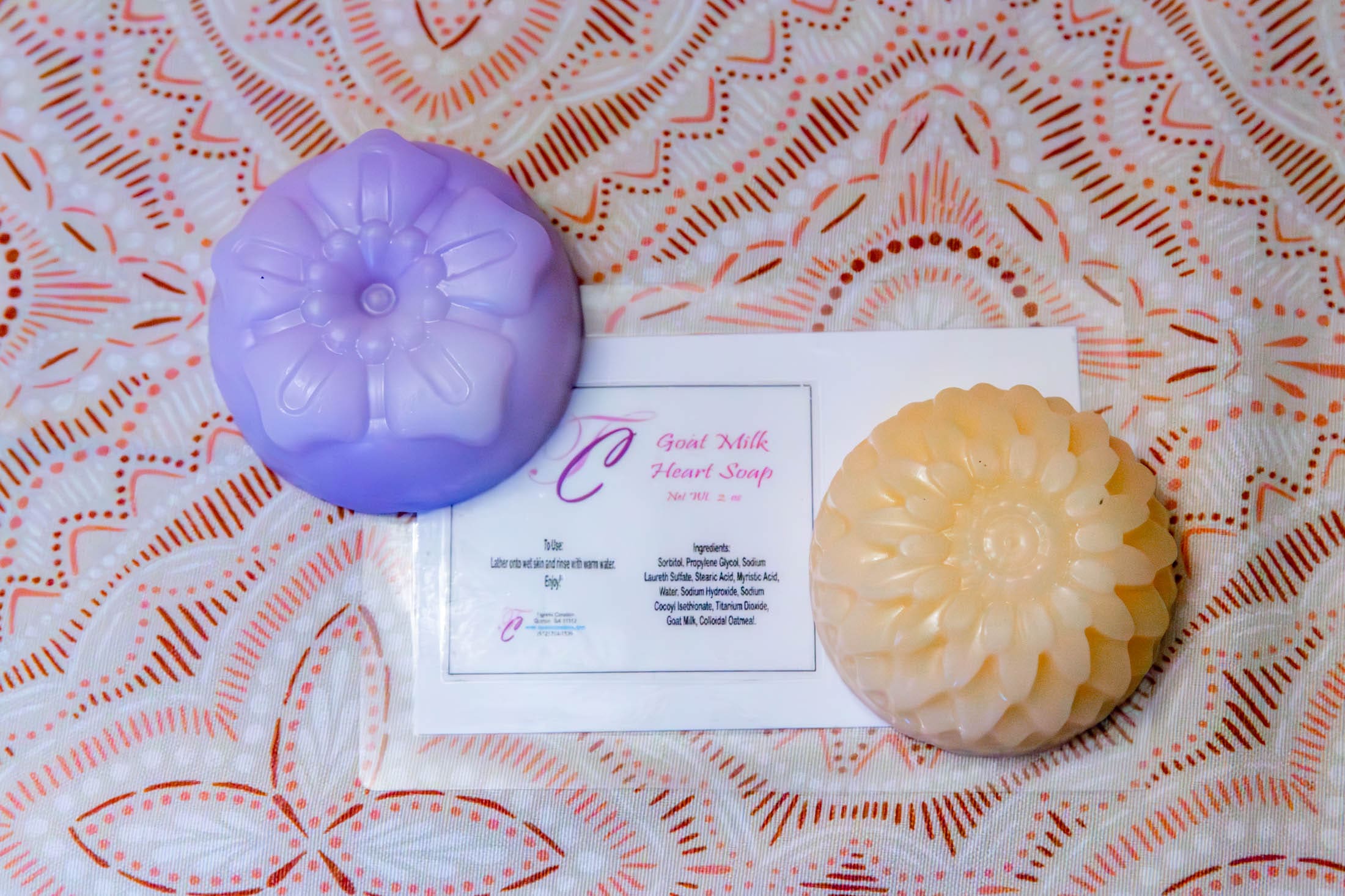 Purple and beige flower-shaped soaps on fabric.